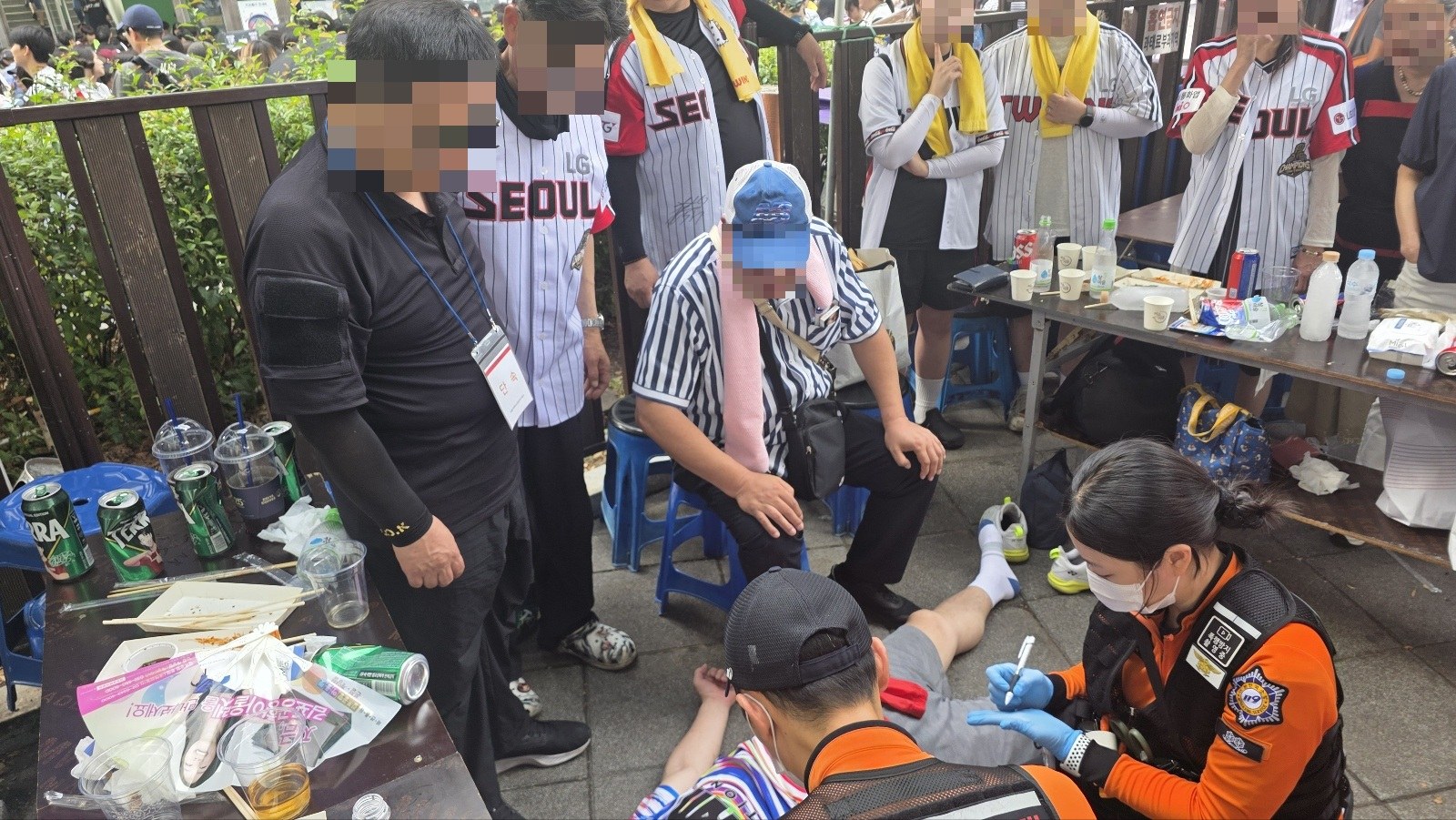 서울시 노점단속 용역팀이 잠실야구장에서 쓰러진 70대 야구팬을 긴급 구조하고 있다.